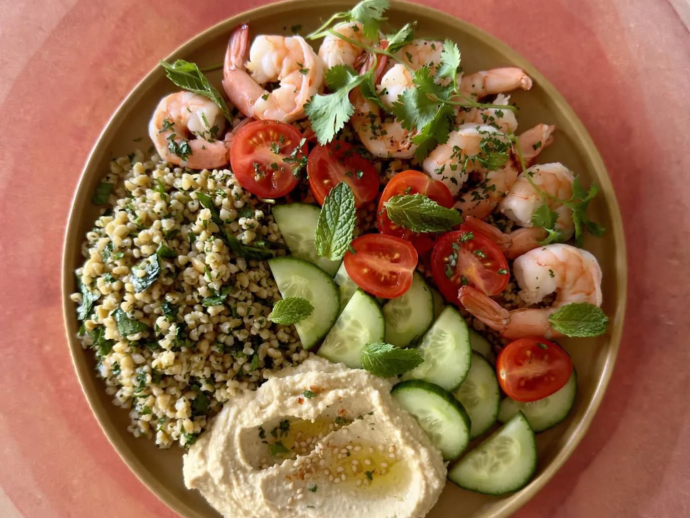 A bowl with prawns, bulgur and hummus